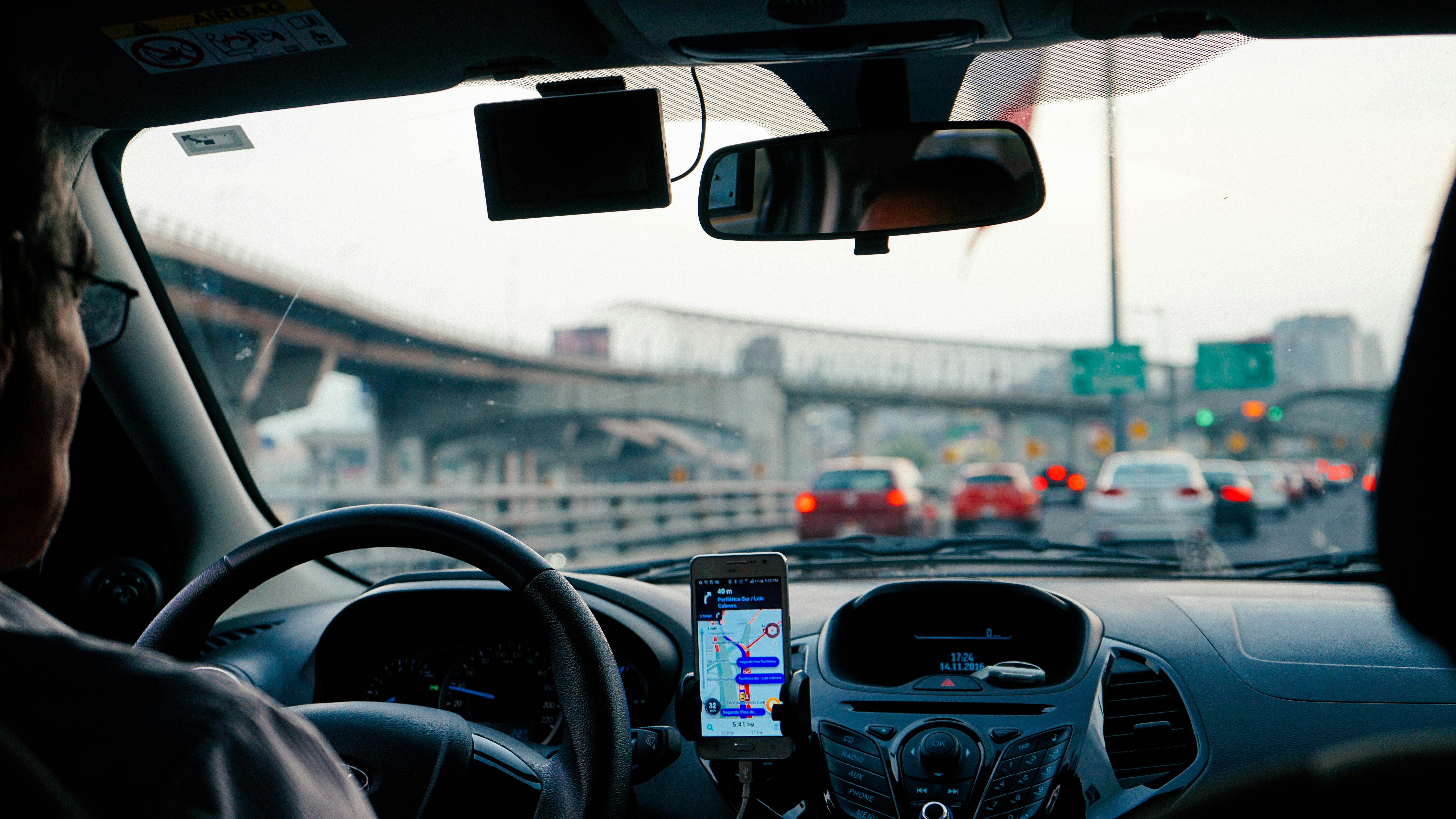 Dashboard view with phone GPS navigating city traffic