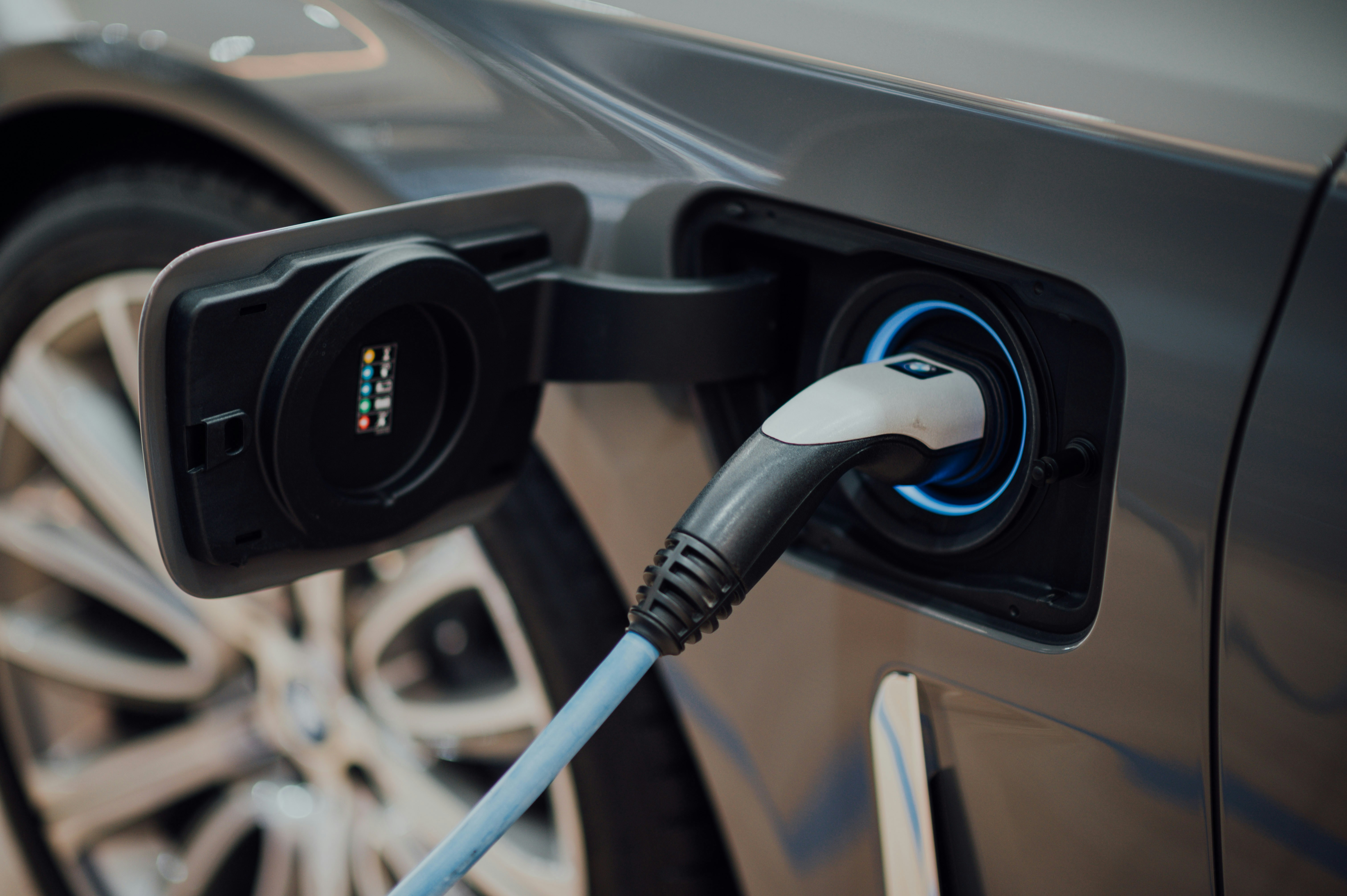 Closeup of an electric vehicle charge port with cable connected