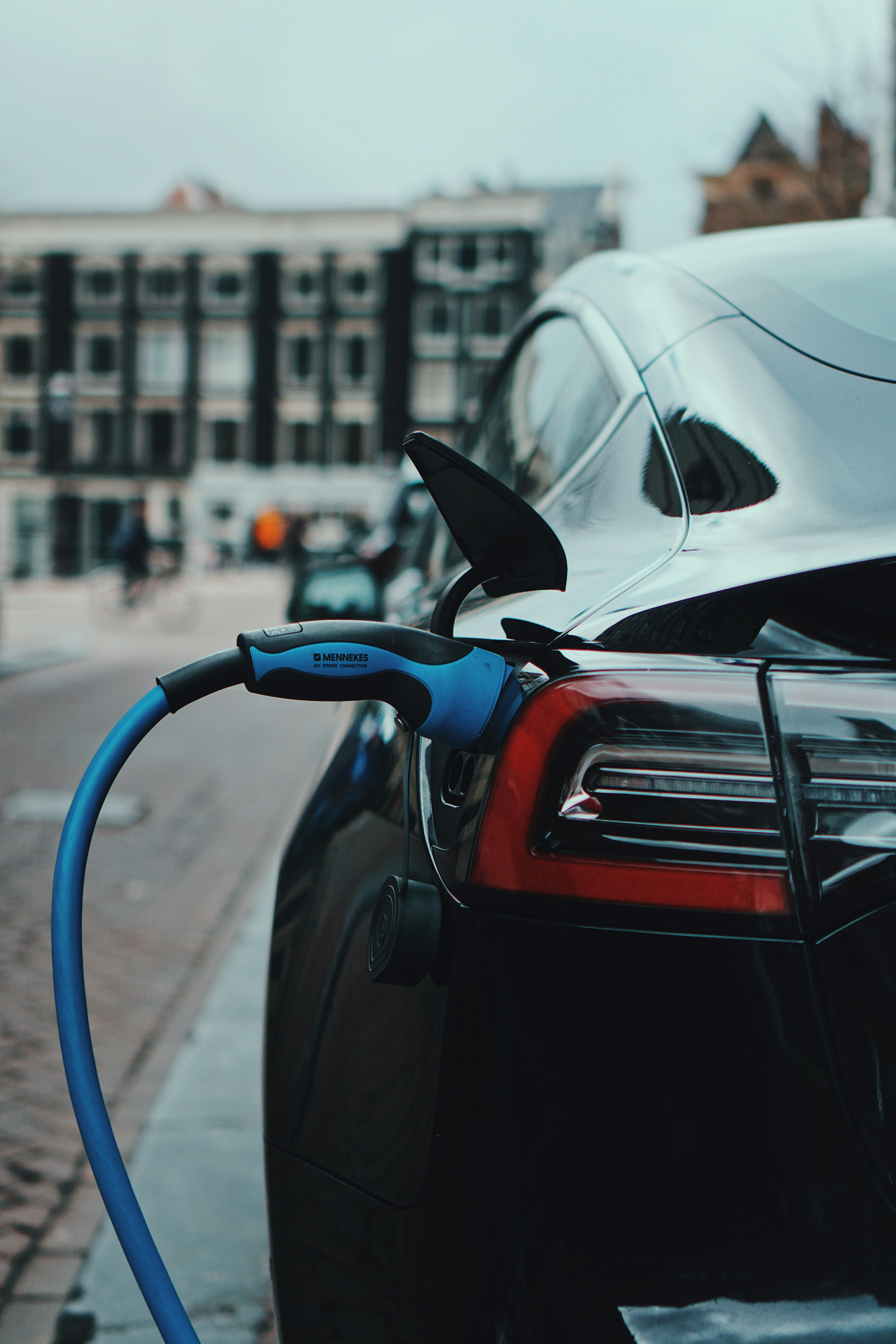 Electric vehicle charging with blue cable on a city street