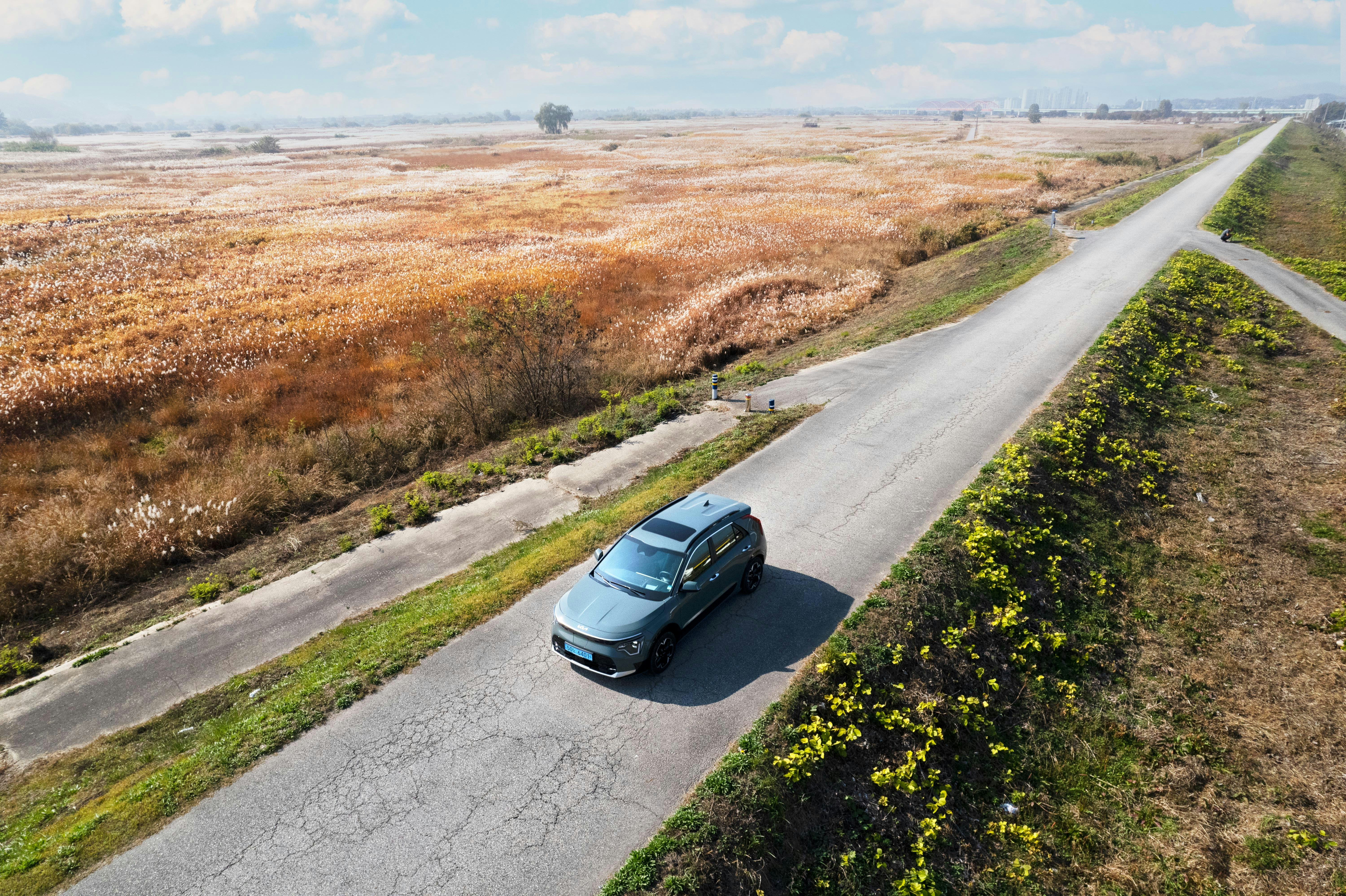 Electric SUV driving on a country road seen from above
