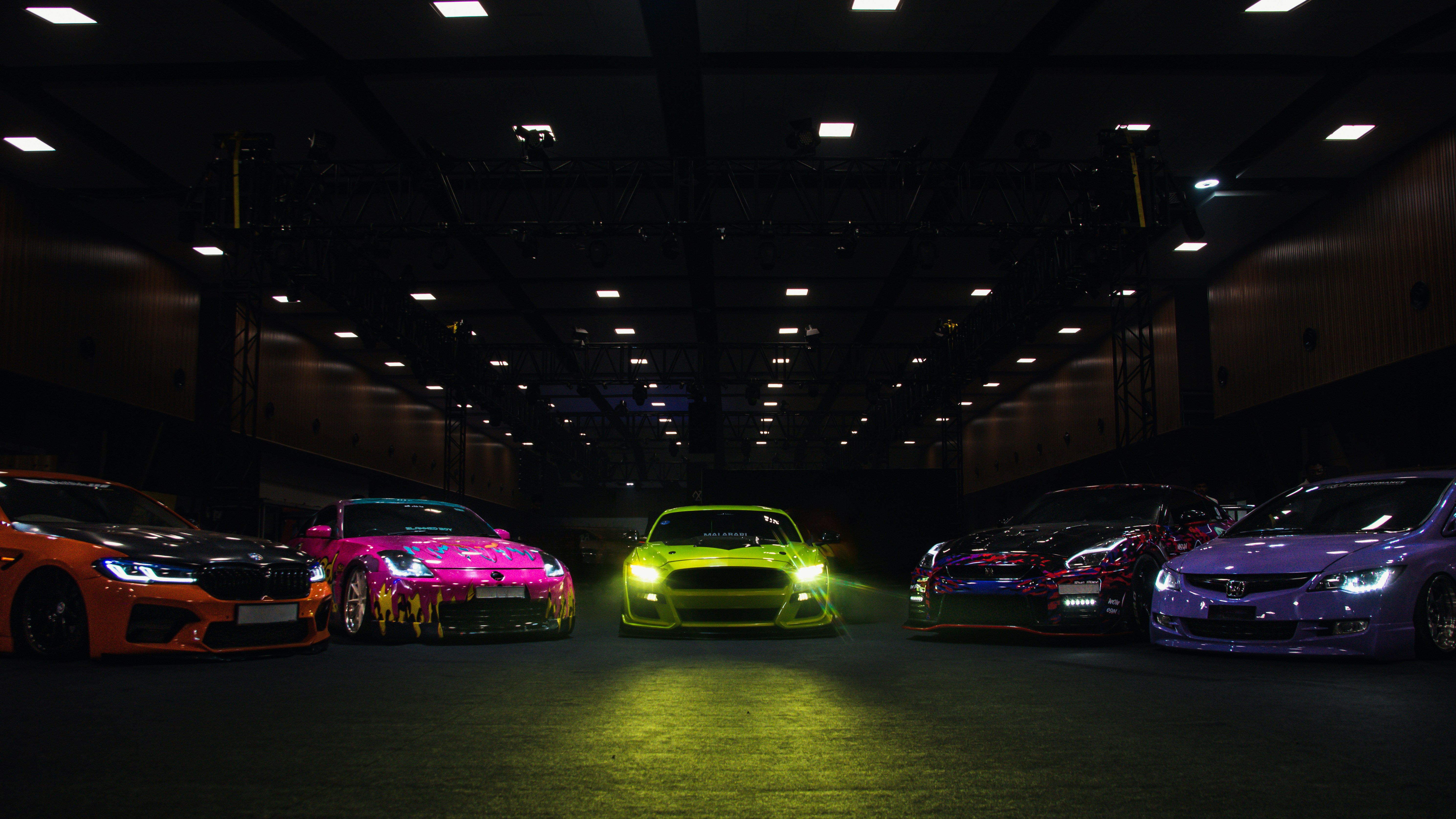 Colorful lineup of cars at a car show with vibrant paintwork