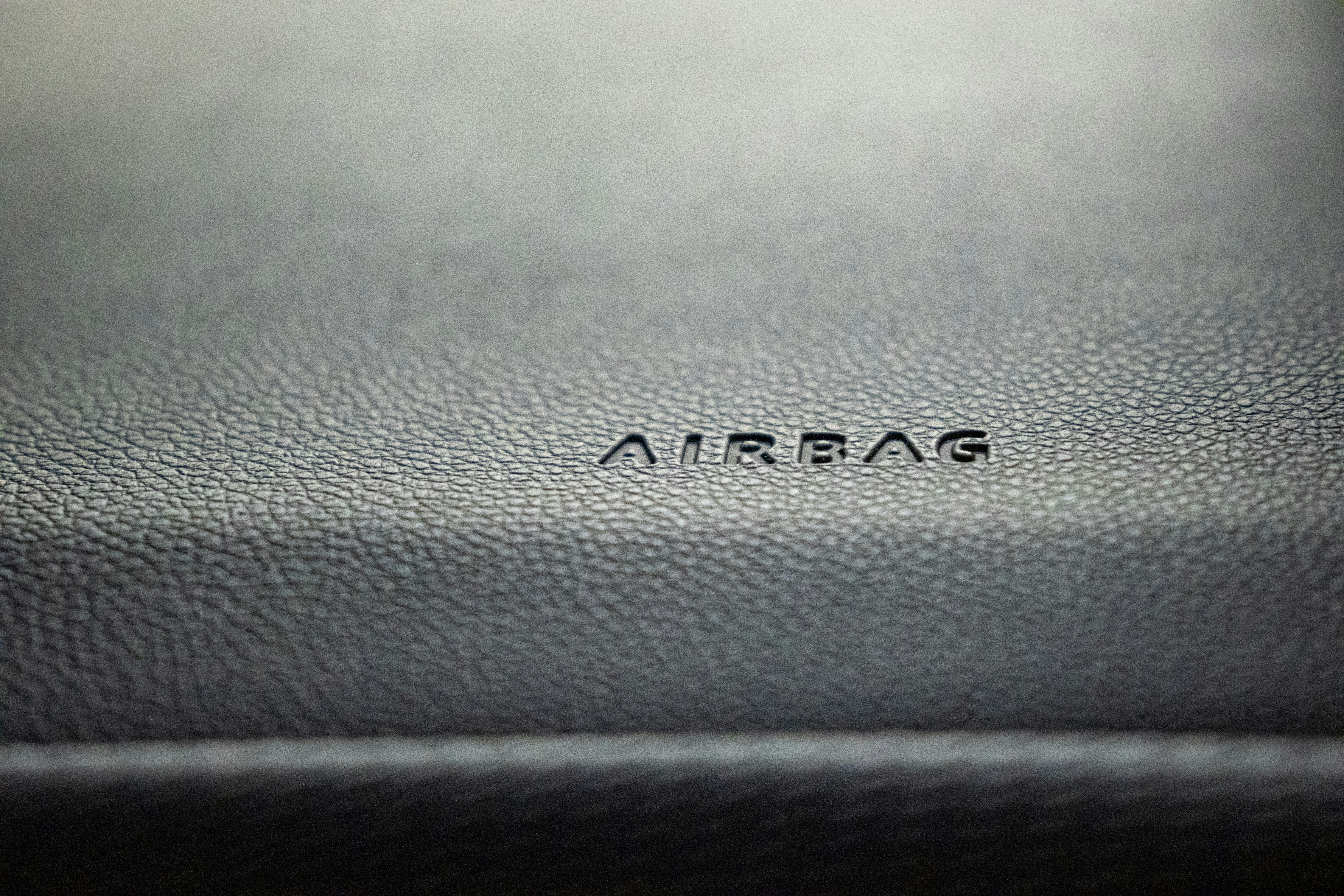 Closeup of AIRBAG text embossed on leather dashboard