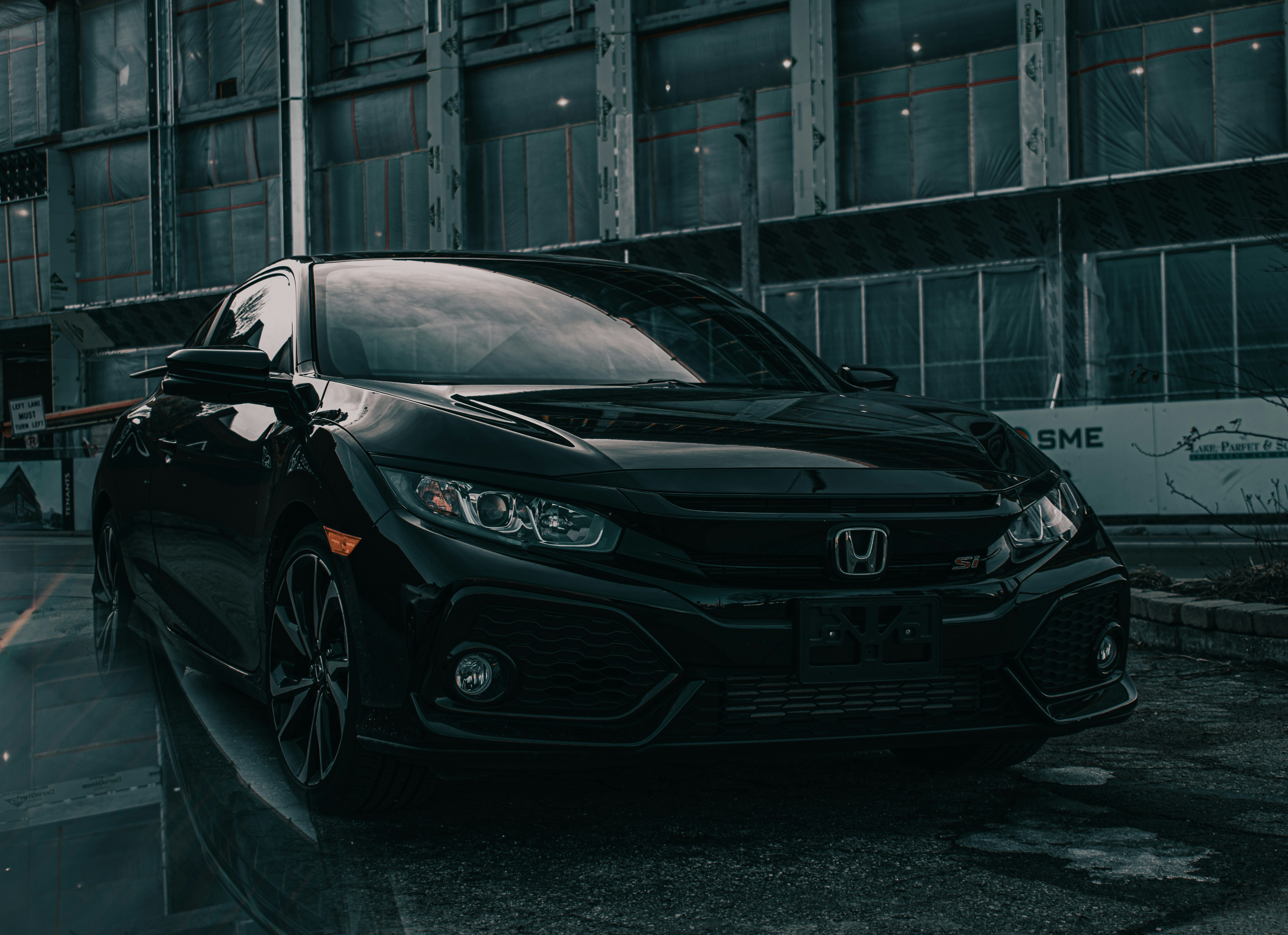 Black Honda Civic Si parked in an urban industrial setting
